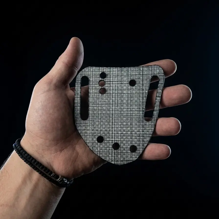 Hand holding a precision-cut Tegris belt slide